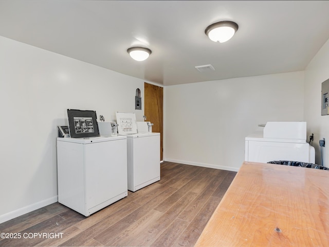 clothes washing area with hardwood / wood-style floors and independent washer and dryer