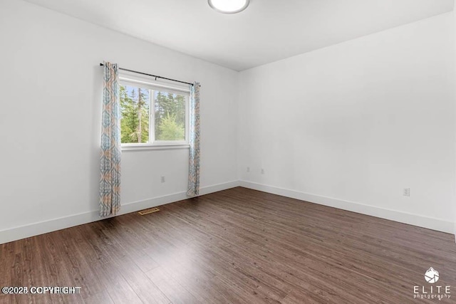 unfurnished room featuring dark wood-type flooring