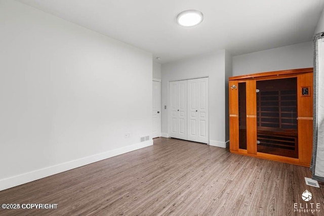 unfurnished bedroom with wood-type flooring and a closet