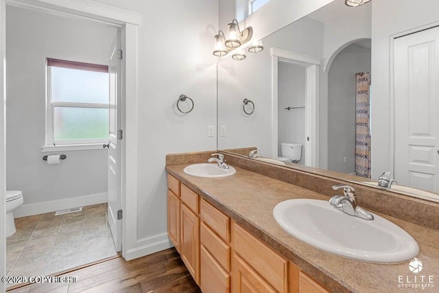 bathroom featuring vanity, hardwood / wood-style floors, and toilet