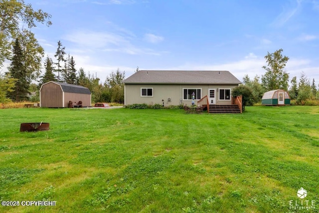 rear view of house with a yard, a deck, and a storage unit