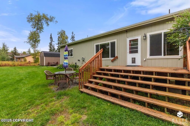 rear view of property featuring a wooden deck, a shed, and a lawn