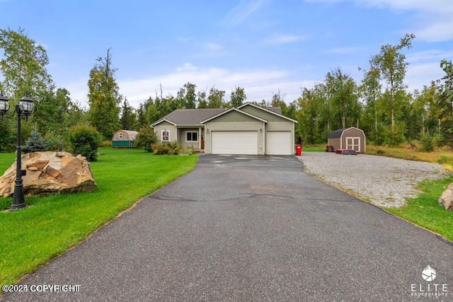 view of front facade featuring a garage, a shed, and a front lawn