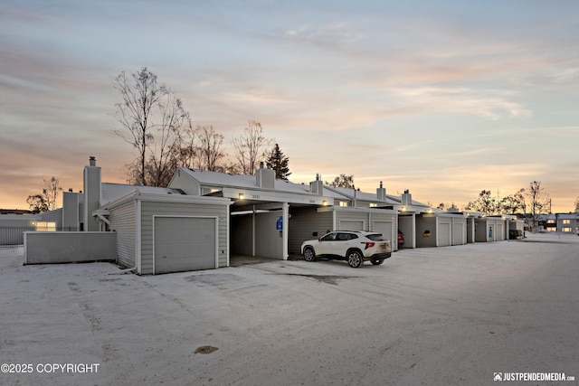 parking at dusk featuring a garage