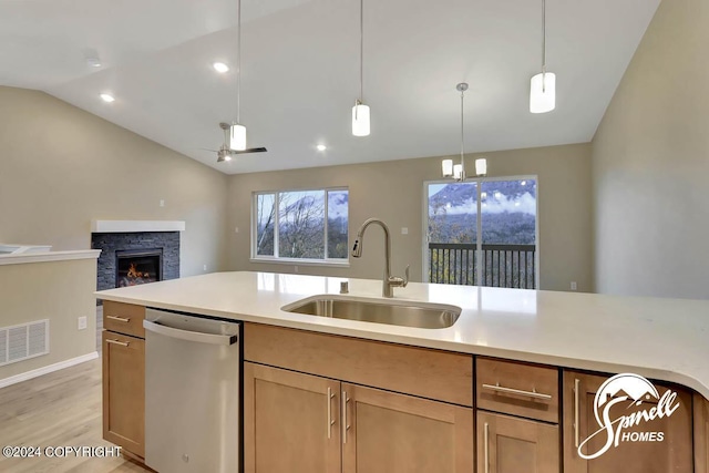 kitchen with vaulted ceiling, a fireplace, sink, stainless steel dishwasher, and ceiling fan