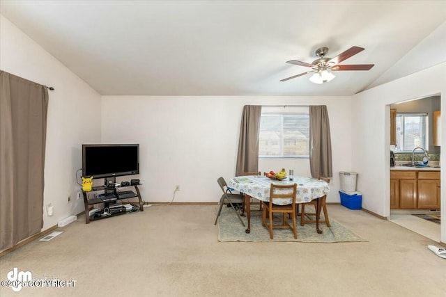 dining area with lofted ceiling, sink, light carpet, and ceiling fan