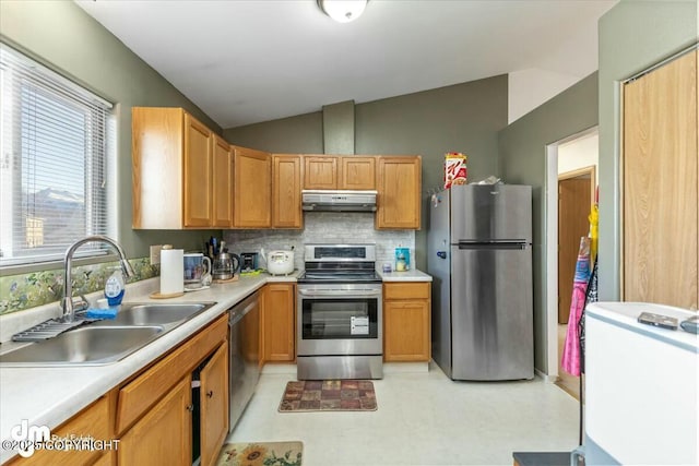 kitchen featuring appliances with stainless steel finishes, sink, lofted ceiling, and decorative backsplash