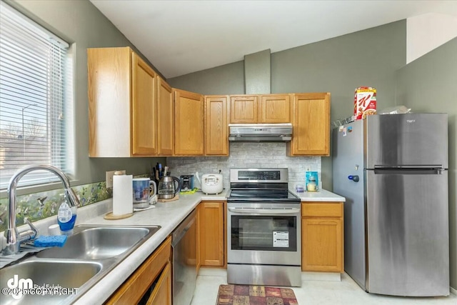 kitchen featuring vaulted ceiling, appliances with stainless steel finishes, sink, and backsplash