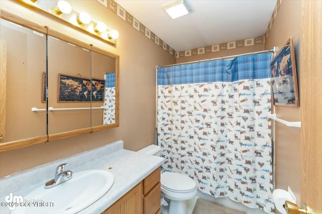 bathroom featuring vanity, a shower with shower curtain, and toilet