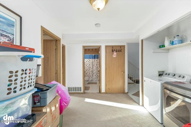 laundry area with light carpet and independent washer and dryer