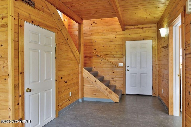 hall with wood ceiling, wooden walls, and beamed ceiling