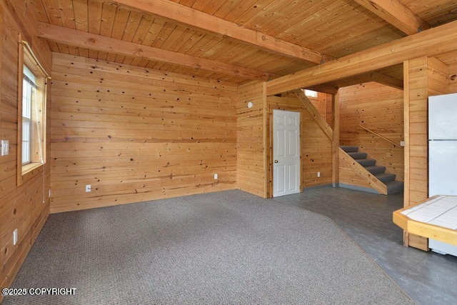 empty room featuring wood ceiling, beam ceiling, and wooden walls