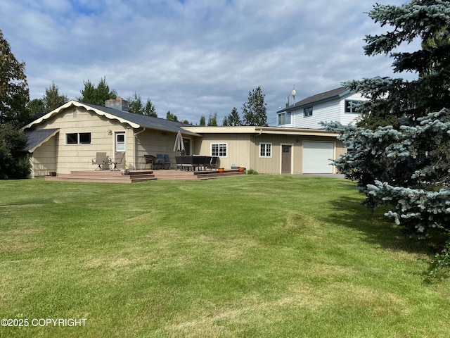 back of house featuring a wooden deck, a garage, and a yard