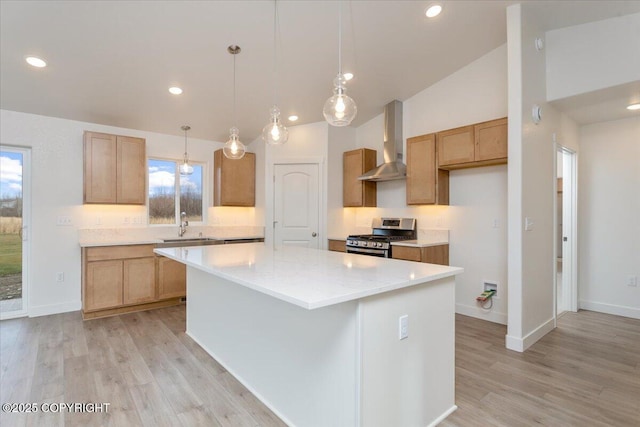 kitchen featuring stainless steel range with gas cooktop, pendant lighting, a kitchen island, and wall chimney exhaust hood