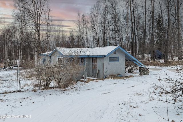 snow covered structure with fence