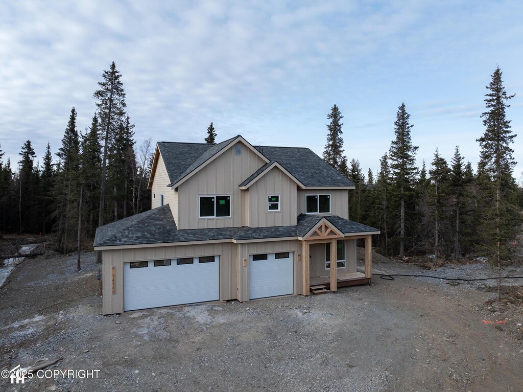 14566 Rockingham Cir, Anchorage, AK 99516 - view of front of property with driveway, board and batten siding, a porch, a garage, and roof with shingles