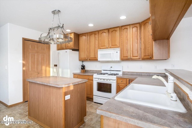 kitchen featuring sink, a center island, pendant lighting, and white appliances