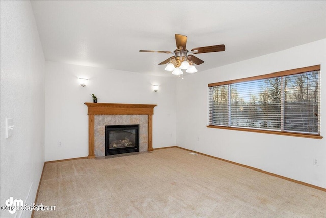 unfurnished living room with a tiled fireplace, light carpet, and ceiling fan