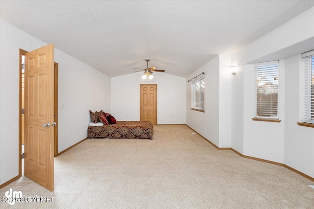 bedroom with ceiling fan, vaulted ceiling, light carpet, and a textured ceiling