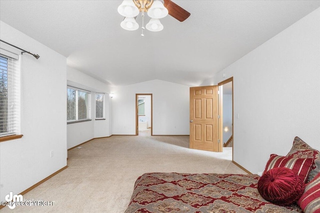 bedroom with lofted ceiling, light colored carpet, and a textured ceiling