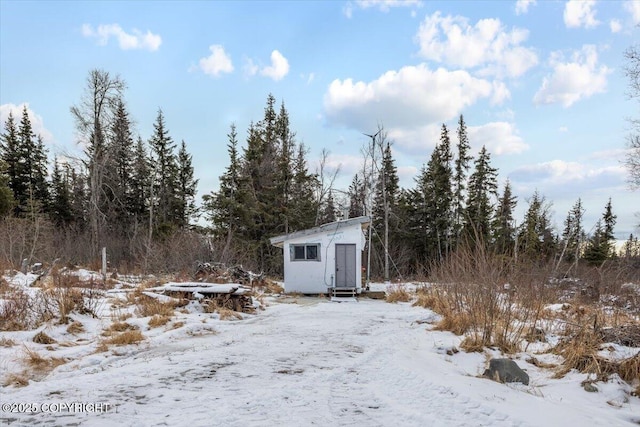 snowy yard featuring a storage shed