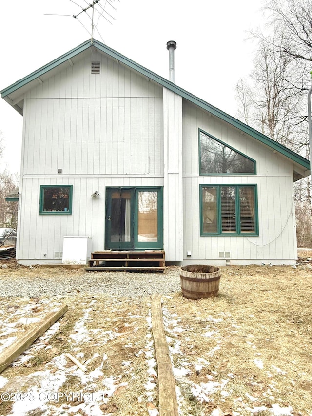 snow covered property with entry steps and crawl space