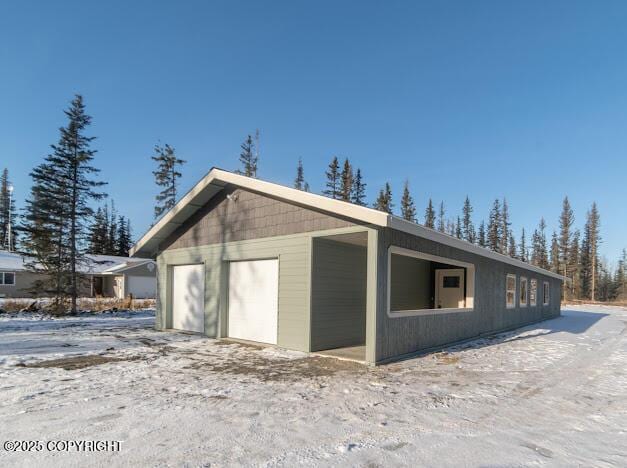 view of snowy exterior featuring a garage