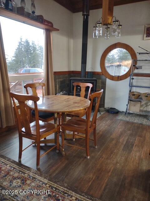 dining space with a wood stove, dark wood-type flooring, and tile walls