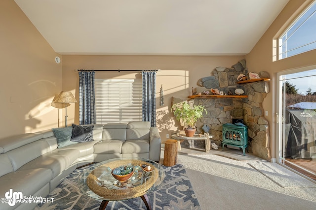 living room with lofted ceiling, carpet floors, and a wood stove