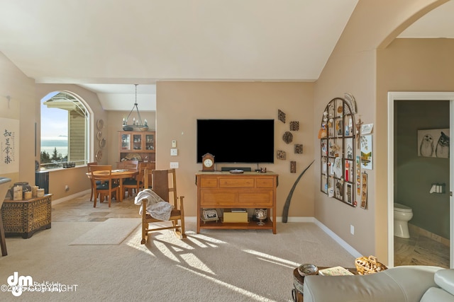 carpeted living room with a chandelier