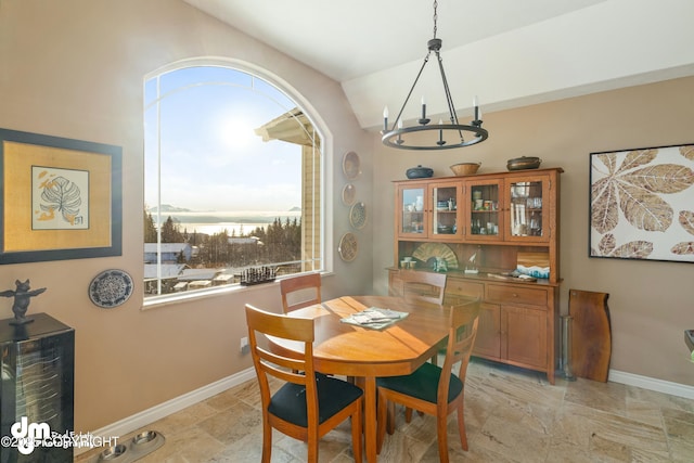 dining room with vaulted ceiling and an inviting chandelier