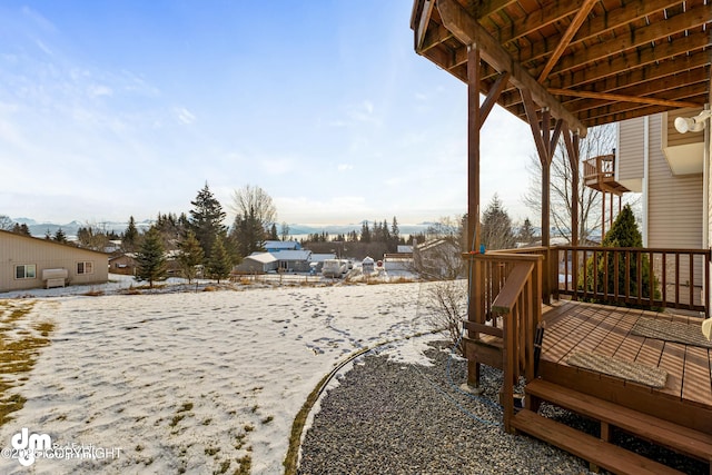 snowy yard featuring a wooden deck