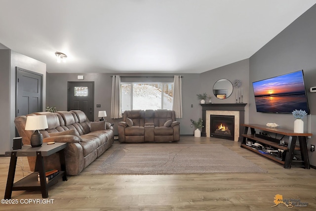 living room featuring vaulted ceiling and light hardwood / wood-style flooring