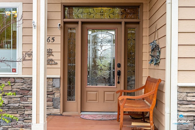 property entrance featuring stone siding and covered porch