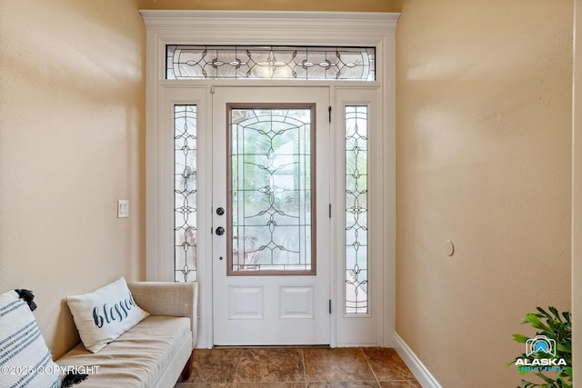 entrance foyer with baseboards and dark stone finish floors
