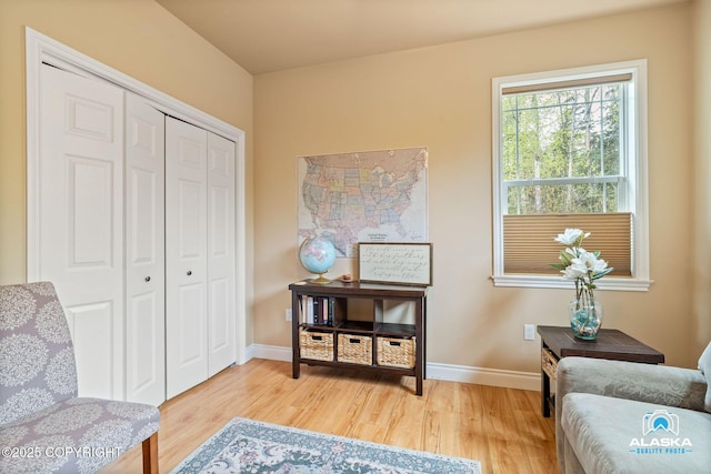 living area featuring light wood-style floors and baseboards