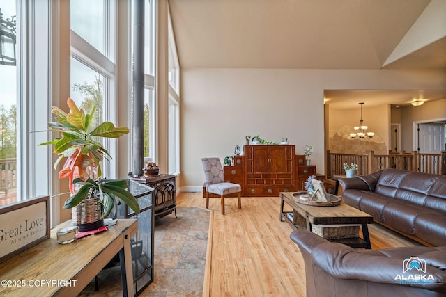 living room featuring a chandelier, wood finished floors, a towering ceiling, and baseboards