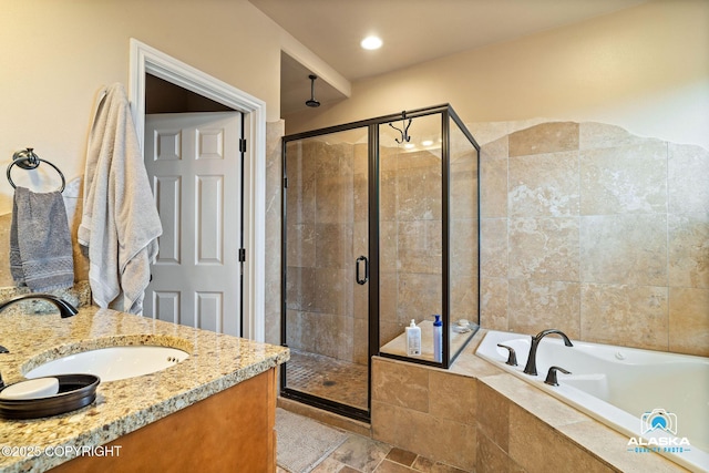 full bathroom featuring a stall shower, a garden tub, and vanity