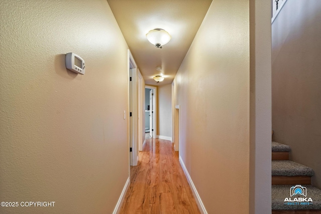 hallway featuring light wood-style floors and baseboards