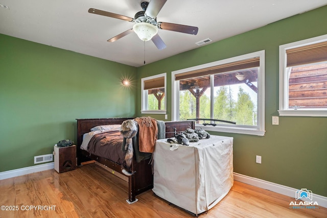 bedroom featuring baseboards, wood finished floors, and ceiling fan