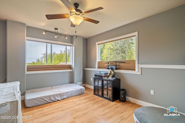 bedroom with wood finished floors, baseboards, and a ceiling fan