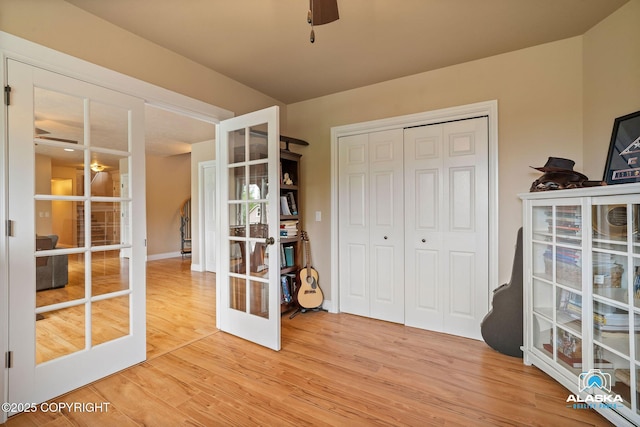 unfurnished office with ceiling fan, french doors, light wood-style floors, and baseboards