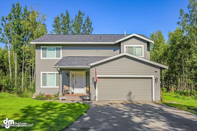 view of front of home featuring driveway, a garage, and a front lawn