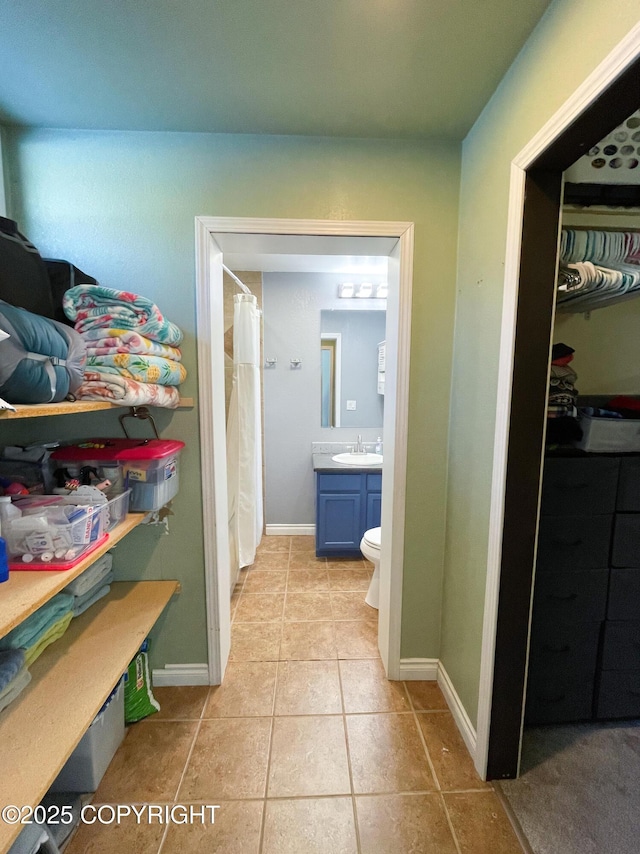 full bath with curtained shower, tile patterned flooring, toilet, vanity, and baseboards