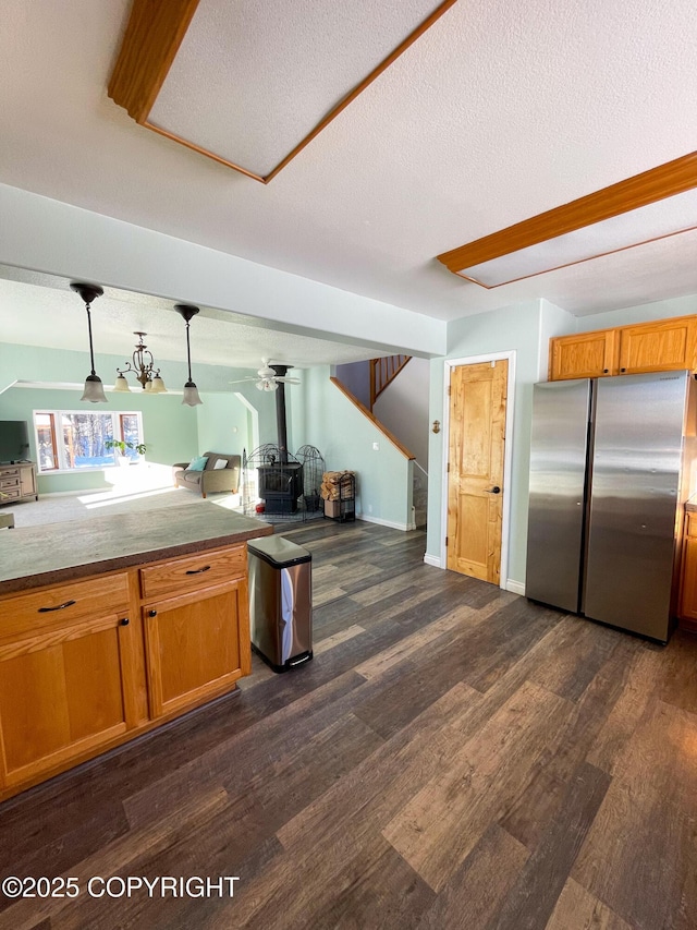 kitchen featuring open floor plan, dark wood-style flooring, brown cabinetry, and freestanding refrigerator