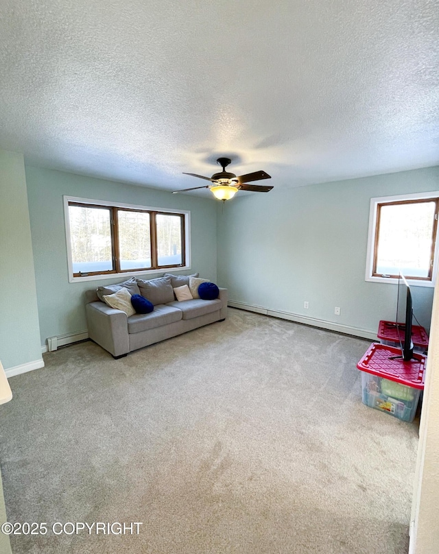 unfurnished living room featuring baseboards, a baseboard radiator, ceiling fan, a textured ceiling, and carpet flooring