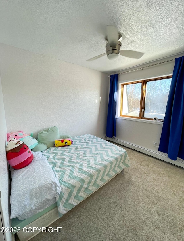 carpeted bedroom featuring a baseboard heating unit, a textured ceiling, and a ceiling fan