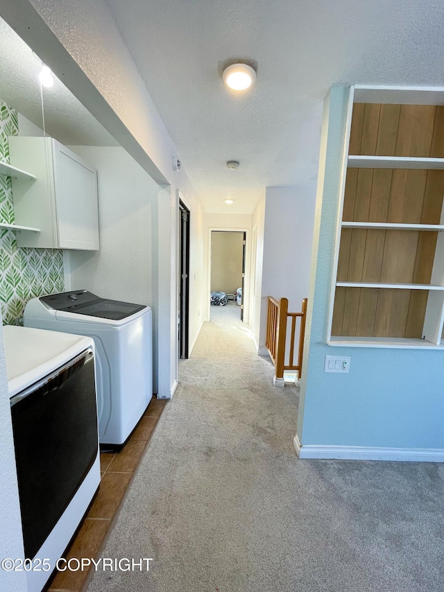 washroom with cabinet space, baseboards, washer and clothes dryer, a textured ceiling, and carpet floors