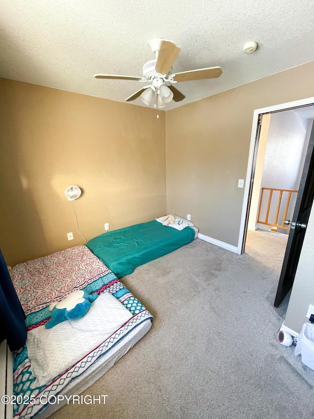 bedroom featuring carpet, baseboards, ceiling fan, and a textured ceiling