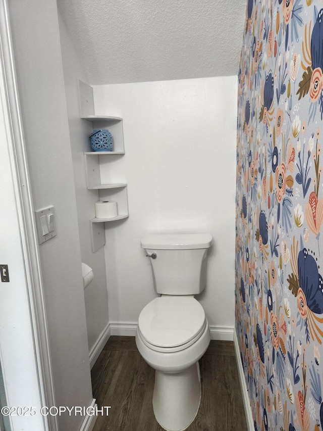 full bathroom featuring baseboards, a textured ceiling, toilet, and wood finished floors